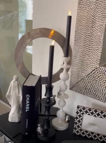 Klant toont de zwarte POLSPOTTEN Climbing Pole Kandelaar gestyled op een tafel, naast een witte variant.