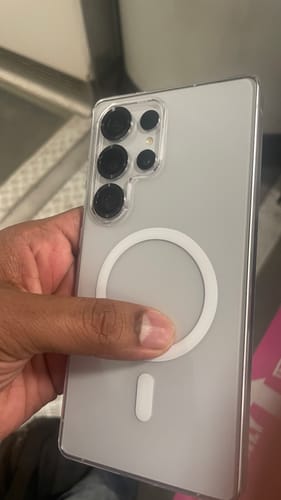 Reviewer holding a Samsung phone in the Anti Yellow Magsafe Clear Case, showing the back and white magnetic ring.