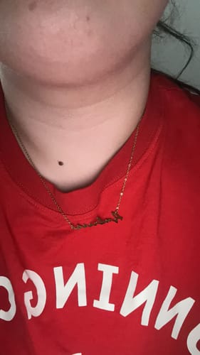 Rezensent in einer Nahaufnahme mit der vergoldeten Signature Namenskette am Hals.