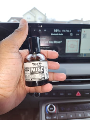 Un cliente tiene in mano la boccetta del profumo VESEVO all'interno di un'auto.