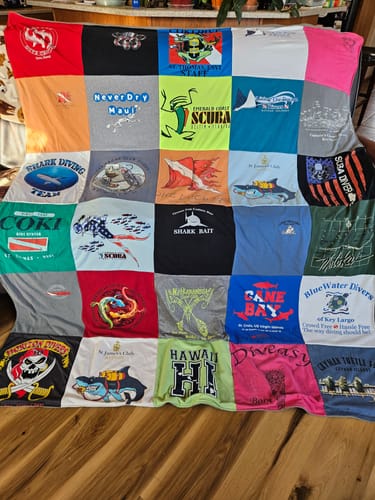 Customer's custom Premium T Shirt Quilt made from a colorful collection of their scuba diving shirts.