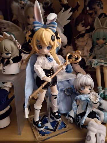 A customer's Start Again Series Alice figure posed with a blue cape and holding a large golden key.