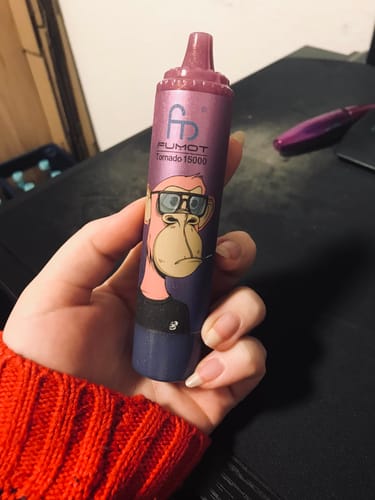 Ein Kunde hält den lila RANDM TORNADO 15000 Vape mit einem Cartoon-Affen in der Hand.