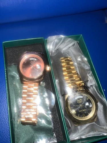 Customer's two Lucky Fours® Santos watches, one rose gold and one gold-toned, inside a green box.