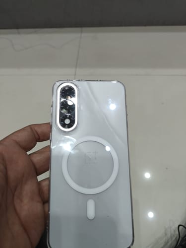 Customer holding a phone with the clear Magsafe case, showing the white magnetic ring on the back.