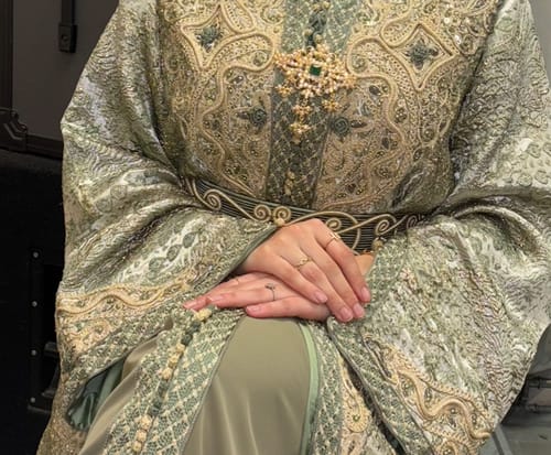 Customer's close-up of the Opulent Sage Green dress, showing the intricate gold embroidery on the chest and belt.