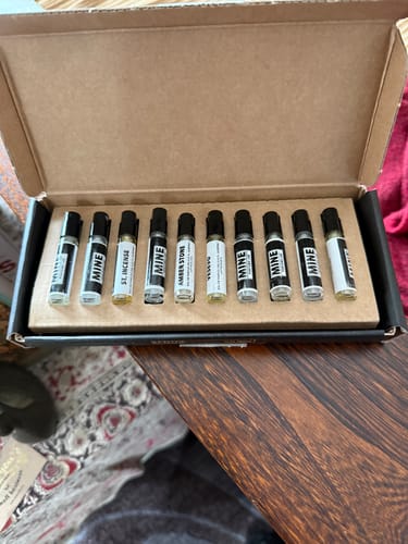 Un cliente mostra la scatola aperta del Set campioni orientali e legnose, con le fiale di profumo allineate all'interno.