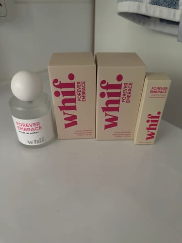 Reviewer's used bottle of Forever Embrace perfume with two large and one small new box of the same scent.
