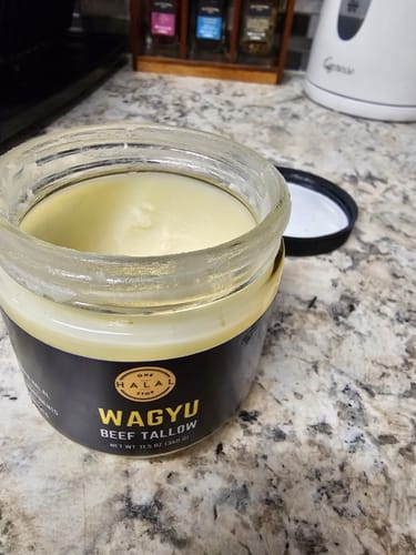 Customer's open jar of Halal Wagyu Beef Tallow on a kitchen counter, showing the smooth, solid product inside.