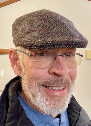 A customer wearing the Tailor Cap Tweed, showing its textured tweed pattern and secure fit.
