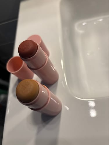 Kundens öppna Bronze & Contour Stick i Golden Truffle bredvid ett matchande blush-stick.
