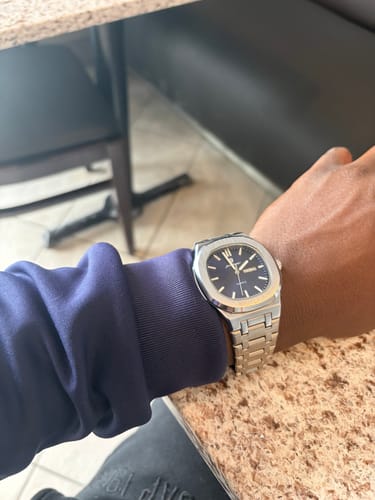 Customer wearing the Lucky Fours® Brone watch with a silver band and dark face on their wrist.