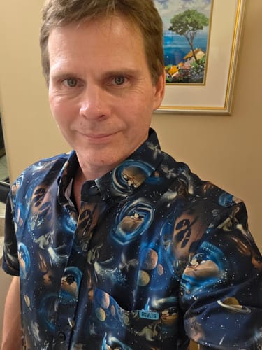 Reviewer wearing the vibrant Fantasia 'Across the Cosmos' short sleeve shirt indoors.