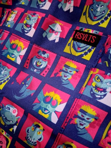 Close-up of a customer's TMNT “Dimension X-cellent” shirt, showing the colorful villain grid pattern and pocket tag.