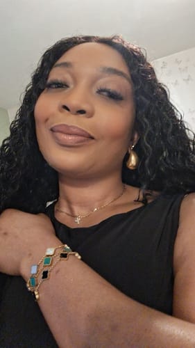 A reviewer shows their Celine Clover Bracelet on-wrist, highlighting its black, white, and teal clover charms.