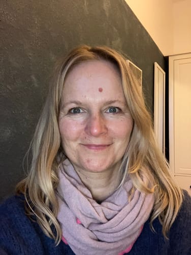 Kundin mit glänzendem, blondem Haar lächelt nach der Anwendung der Apple-Wonder Haarseife.