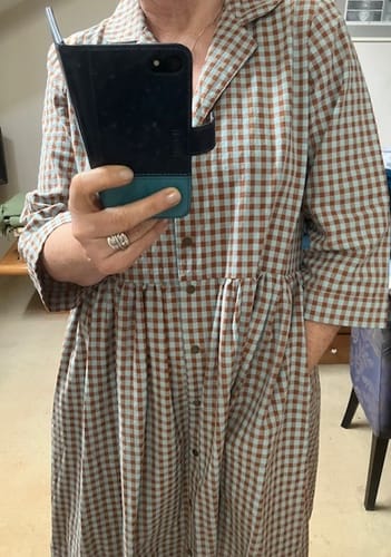 Une cliente portant la robe Julia vichy. La vue de face montre sa coupe légèrement ample et sa poche latérale.