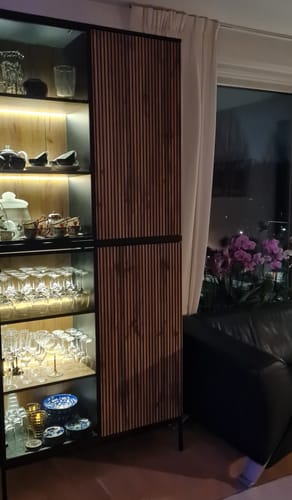 Recensent toont twee Tiana wandkasten op elkaar gestapeld in een woonkamer, met de verlichting aan.