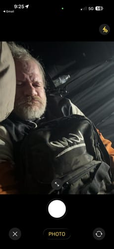 Customer rests their head on the black Mystery Tactical Backpack, using it as a pillow.