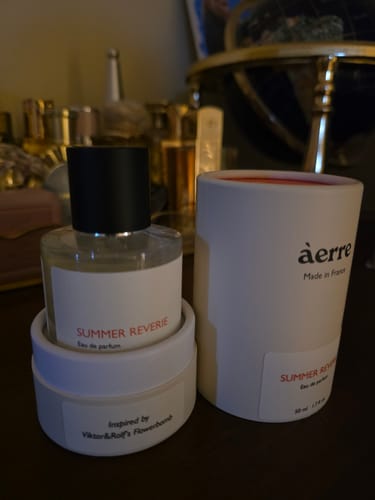 Reviewer's Summer Reverie perfume bottle and its white cylindrical box displayed on a dark surface.