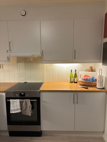 Kundes kjøkken med hvite, glatte skap før påføring av Sonoma Eike Trøffel kontaktplast.