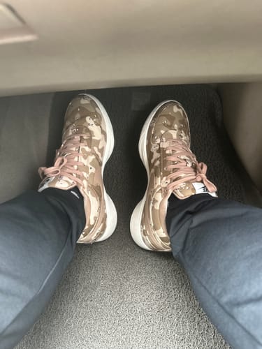 Customer's first-person view of the Nike Book 1 basketball shoes in a desert camouflage pattern.