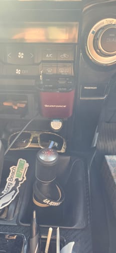 Customer's red 4 in 1 Car Charging Port plugged into a car's dashboard, positioned above the gear shifter.