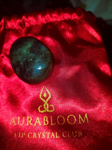 Customer's iridescent labradorite crystal from the VIP Crystal Club, shown on its red satin pouch.