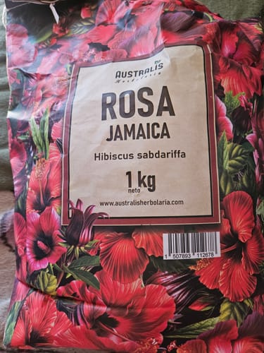 Reseñador muestra la bolsa grande de 1 kg de Rosa Jamaica con un llamativo diseño floral.