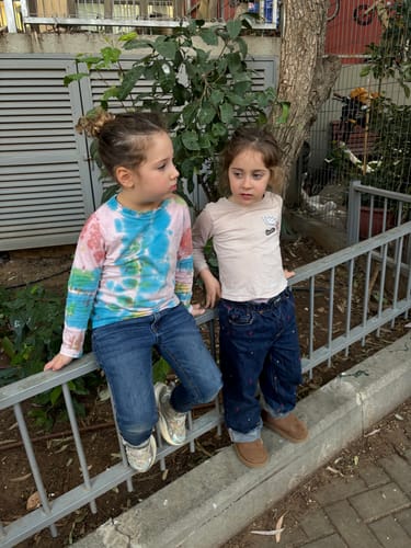 ילדה של מבקרת נועלת את מגפי הפמפה החומים שלה בחוץ.