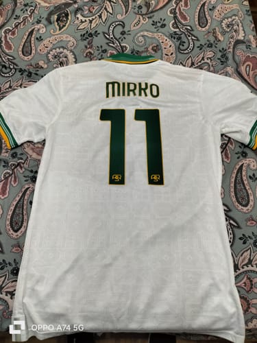 Recensore mostra il retro della TERZA MAGLIA ROMA bianca, personalizzata con nome 'MIRKO' e numero 11 in verde.