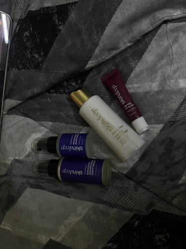 Customer's Niacinamide Glow Drops shown with other skincare products on a patterned blanket.