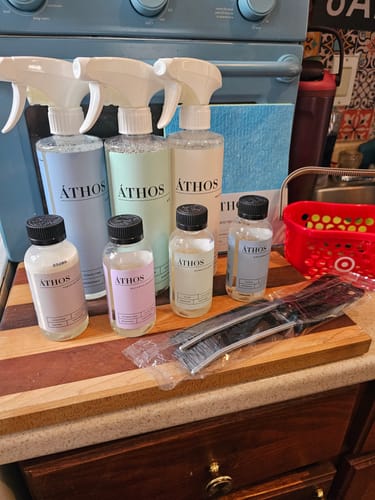 Reviewer's set of Áthos cleaning products, including the Stainless Steel Polish, arranged on a kitchen counter.