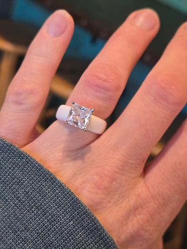 Customer's hand wearing the white Silicone Ring with a large, sparkly princess-cut stone.