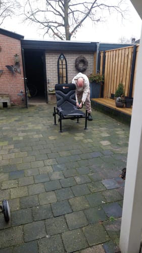 Recensent stelt de zwarte X-LEVEL ACCESSORY CHAIR op een betegeld terras op.