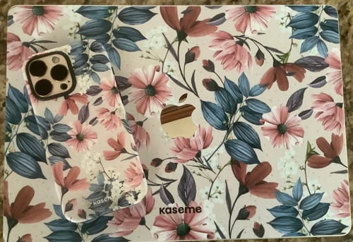 Customer's phone case with 'Fall flowers' design, shown with a matching laptop skin.