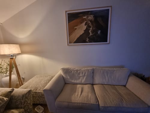 Customer's framed 'Neutral Lands' art print hanging on a living room wall above a light-colored sofa.