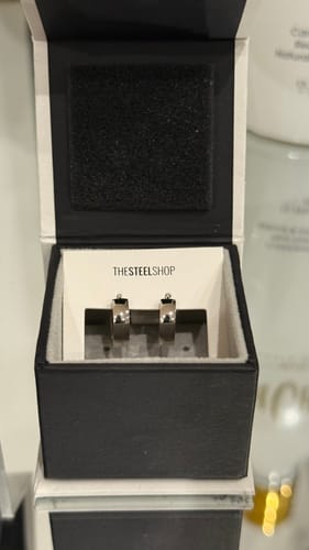 Customer's new Rounded Huggie Earrings presented in their black branded box.
