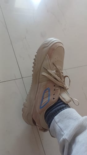 Close-up of a customer wearing the beige Bacca Bucci EVOLVE low-top sneaker.