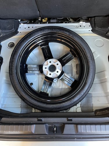 Customer's Braumach space saver spare wheel placed in the silver boot well of a car to demonstrate its fit.
