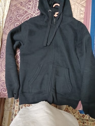 Customer's dusty black Ultra Premium Comfort Hoodie laid out flat, showing the full zip-front, hood, and pockets.