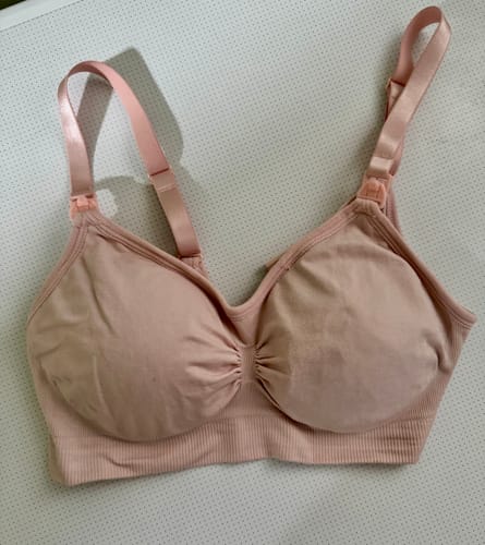 Customer's seamless pink Lovemère Nursing Bra laid flat, showing its adjustable straps and front clips.