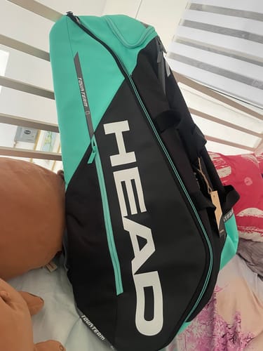 Customer's new black and teal HEAD Tour Team Monstercombi tennis bag resting on a bed.