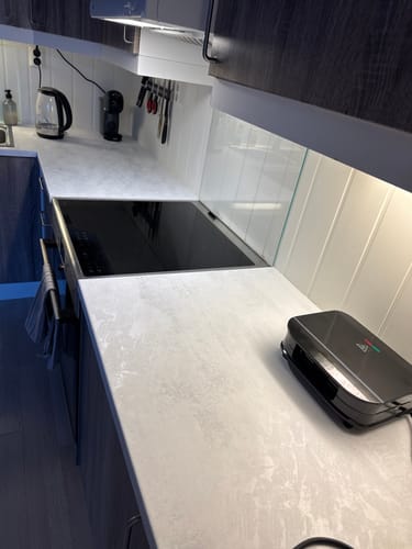 Kundens kjøkkenbenk fornyet med lys mikrosement kontaktplast, som gir et lyst og rent utseende.