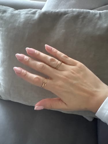 Reviewer's hand wearing the gold Classic Claw Ring on the middle finger, styled with another ring.