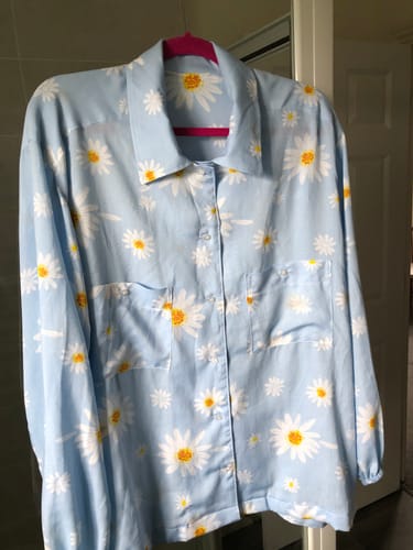 Reviewer's finished light blue blouse with a daisy print, showing the result of using the soft interfacing in the collar.