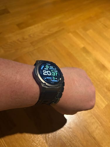 Customer wearing the Gard Pro Ultra 3 smartwatch on their wrist, showing a lit digital face and dark metal band.