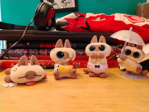 Customer's four charming Nobeko Azukisan cat figurines in various poses on a wooden desk.
