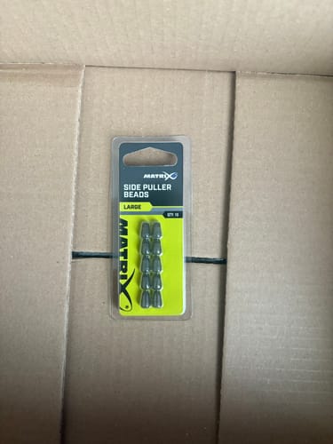 Recensent toont de verpakking van de Matrix Side Puller Beads in een kartonnen doos.