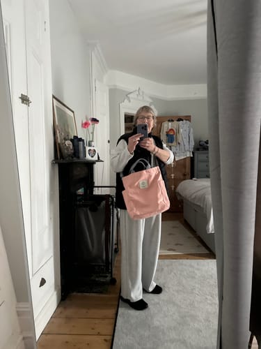 Reviewer holding the pink Canvas Shoulder Bag while taking a mirror selfie in a bedroom.